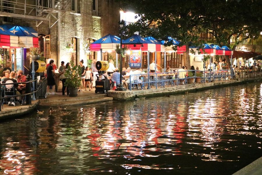 Picture of people enjoying themselves at the sideline of the riverwalk river in San Antonio