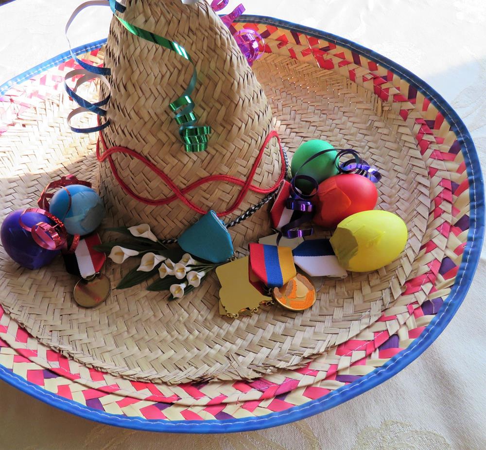 A sombrero with cascarones, medals, shells, and other festive novelties