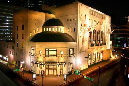 The Nancy Lee and Perry R. Bass Performance Hall lit up at night with the dome and sculpted angels in view.
