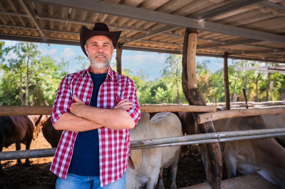 A cattle farmer owner wearing a cowboy hat