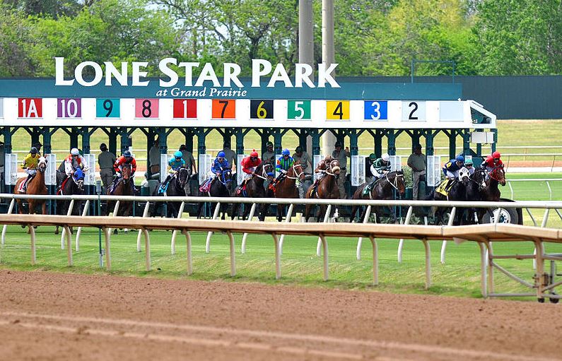 horses and riders starting out of the gate at Lone Star Park