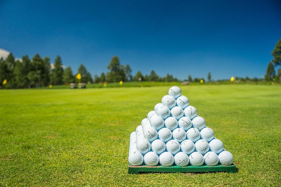 golf balls stacked in a pyramid placed on the golf course