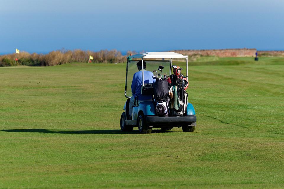 a man driving a golf buggy around the course