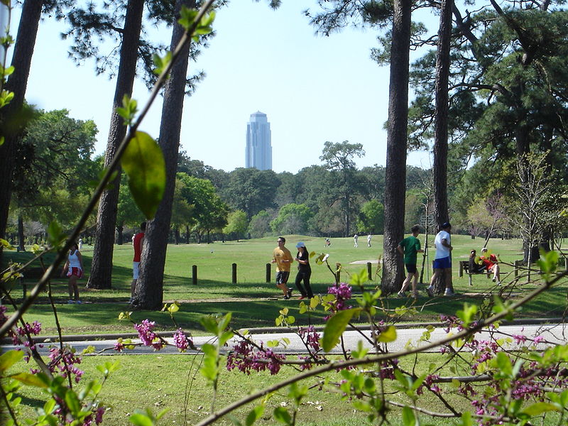 people strolling around the Memorial Park golf course with the Williams Tower in the background