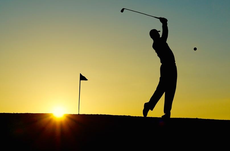 silhouette of a man playing golf