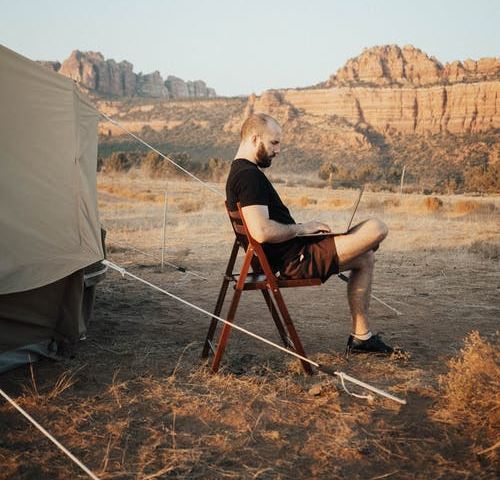A man camping on a desert mountain