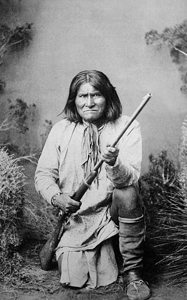 Geronimo (Goyathlay), a Chiricahua Apache, kneeling with rifle