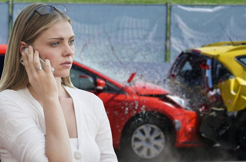 woman making a phone call with car accident behind her