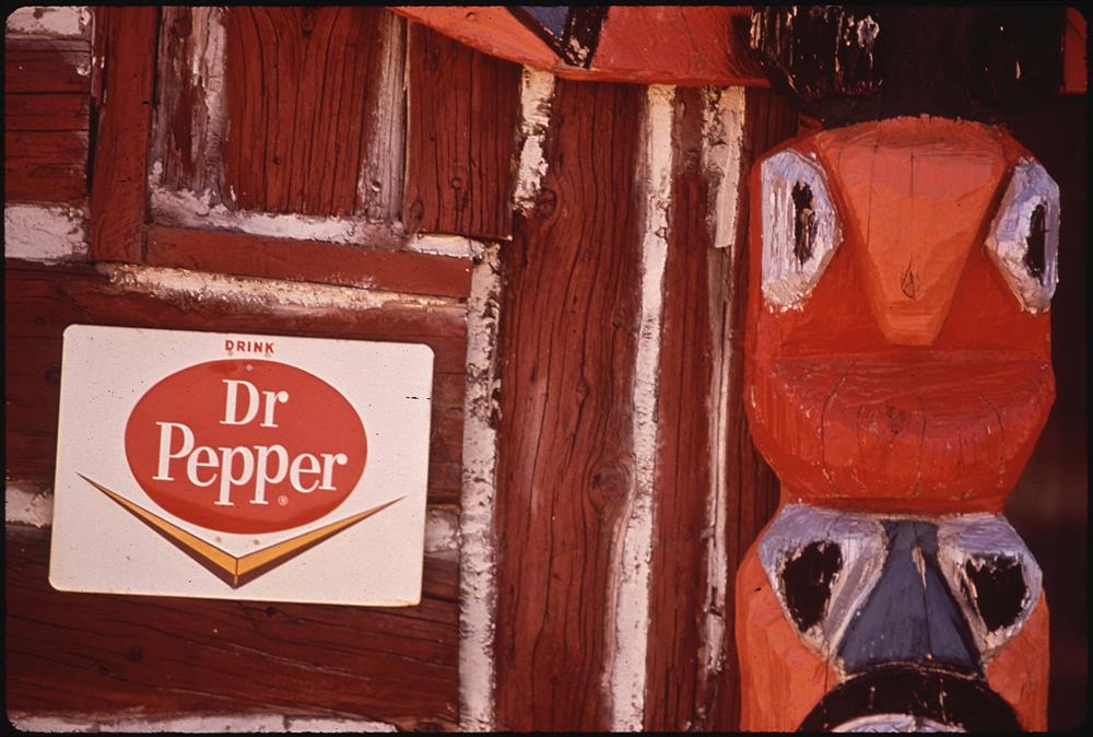 Totem pole at trading post with Drink Dr Pepper sign