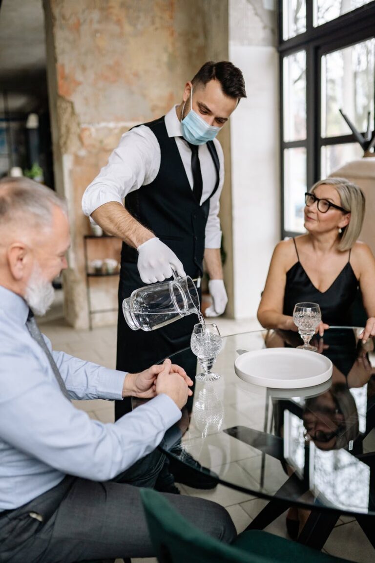 A server pouring water for the customers 