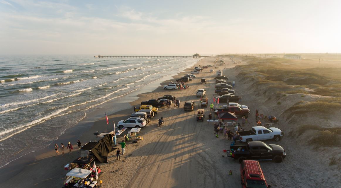 An aerial view of South Padre Island with parked cars along the beach