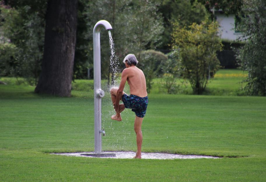 a man showering, man with gray hair, green grass