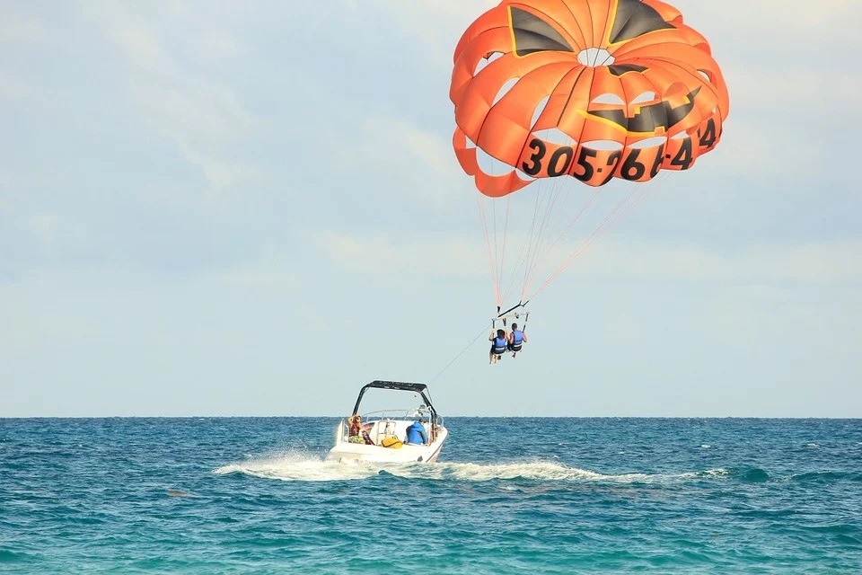 seawater, sky, sailboat, two people parasailing