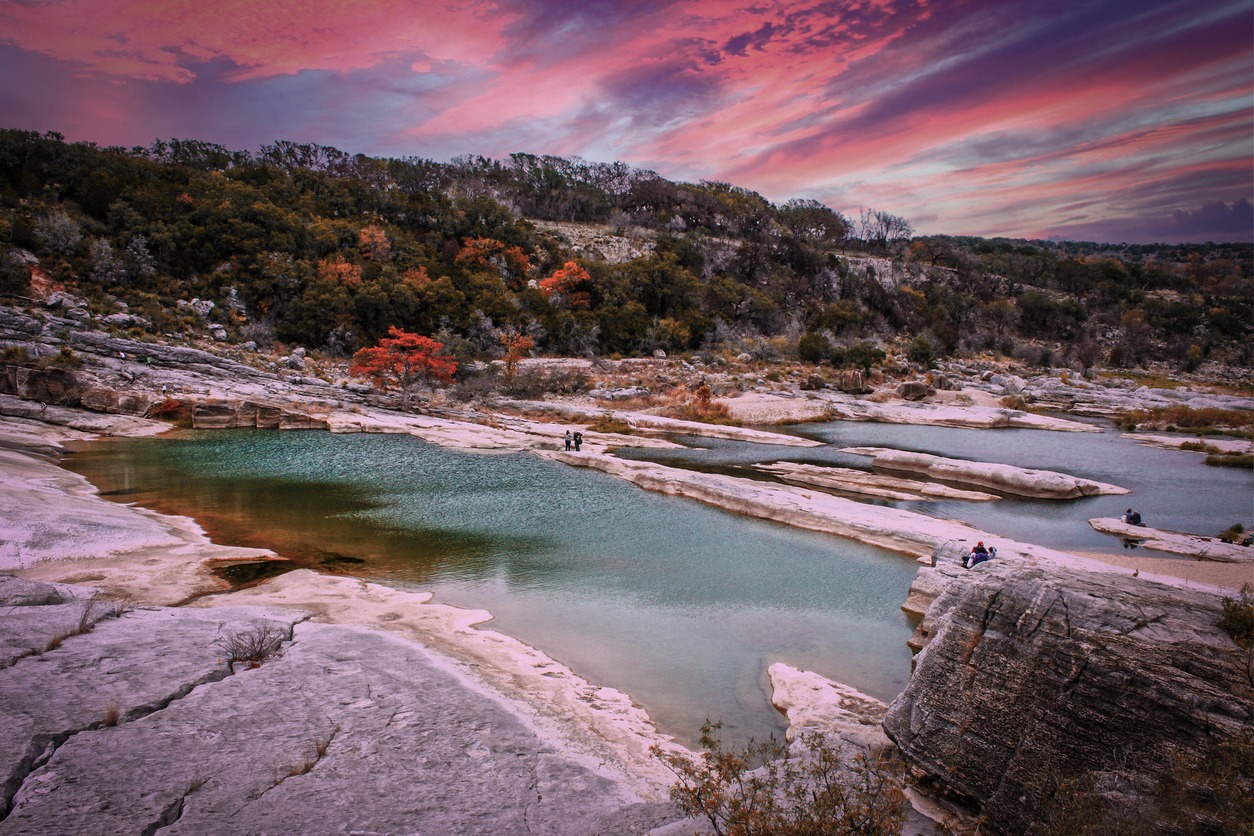 Peranales River that sometimes flows underground near LBJ Ranch in Teaas under crazy sunset sky with fall foliage