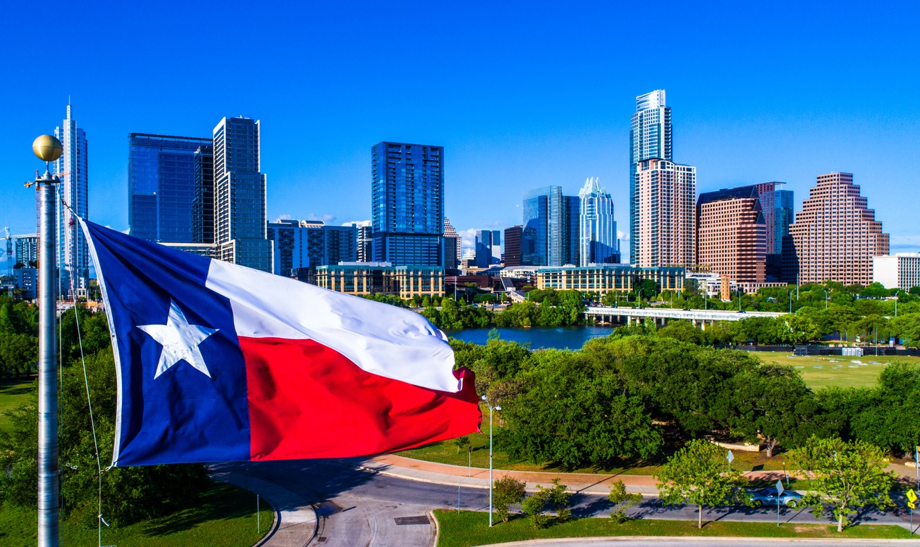 Texas flag flying in front of Austin Texas downtown skyline cityscape