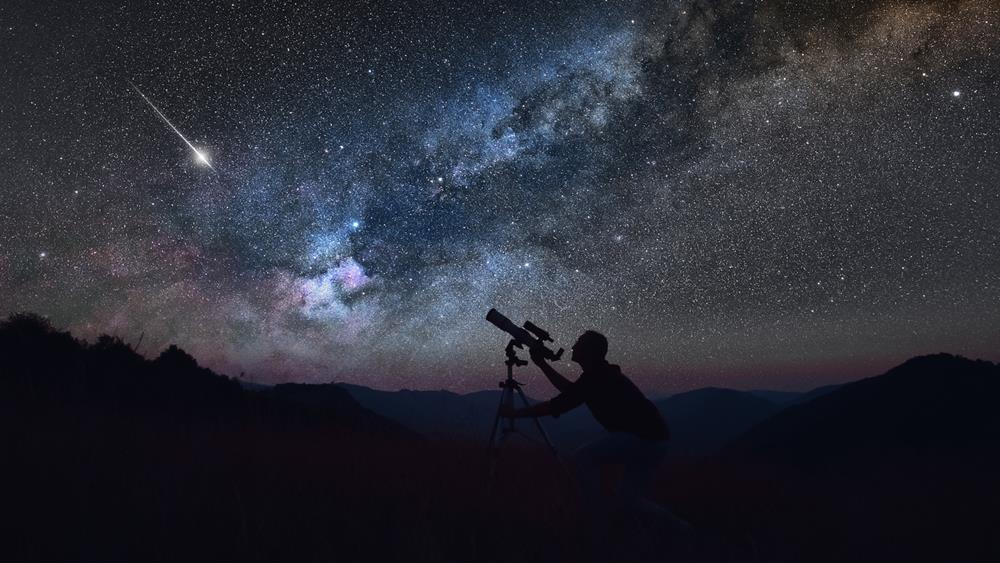 Astronomer looking at the starry skies with a telescope