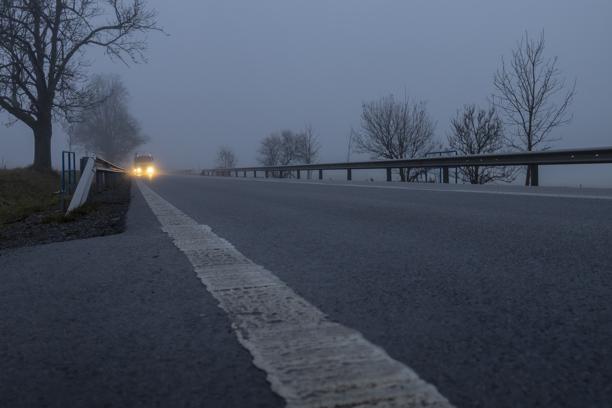 Lighted cars at dusk on main road