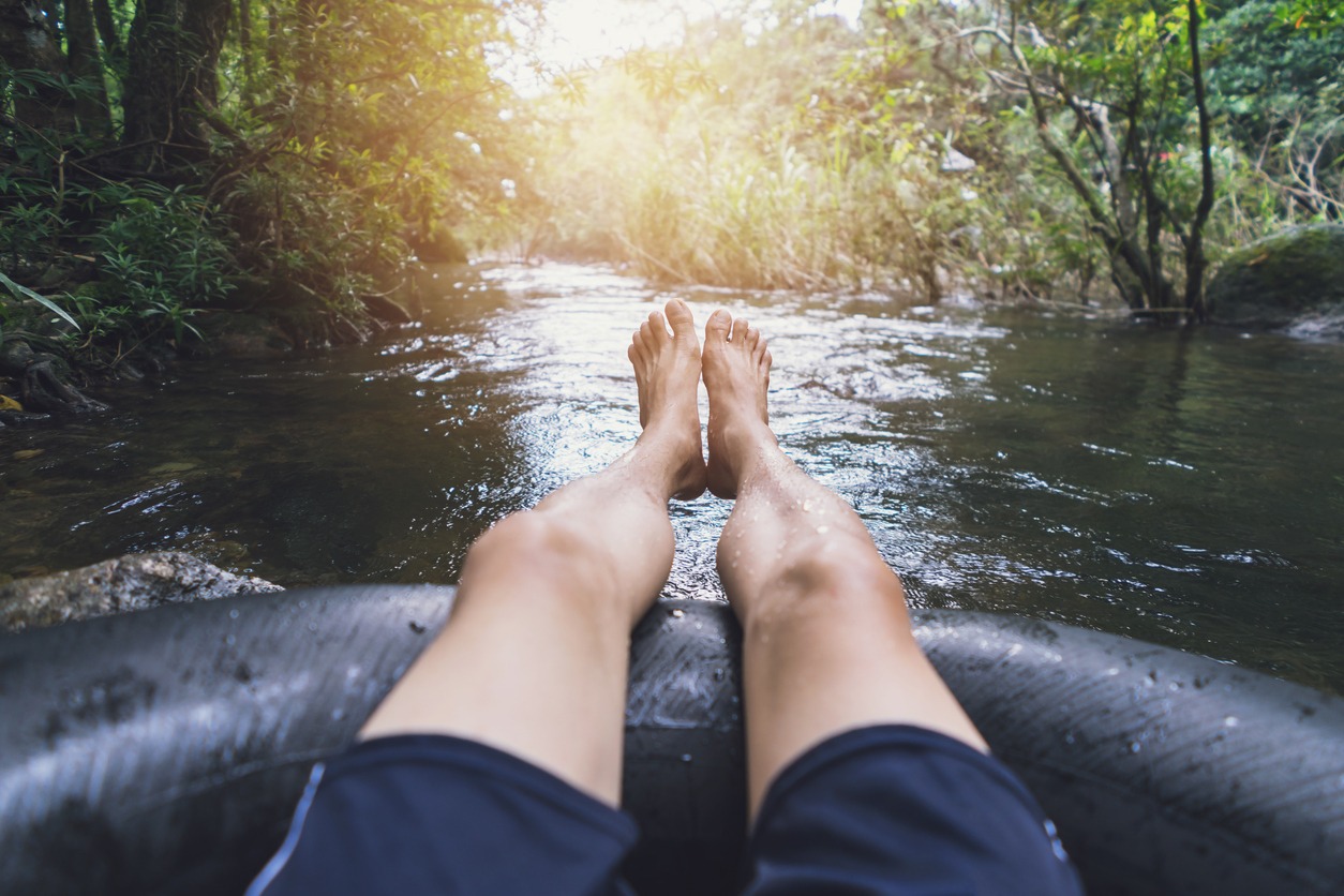 Man floating down a canal in a blow-up tube