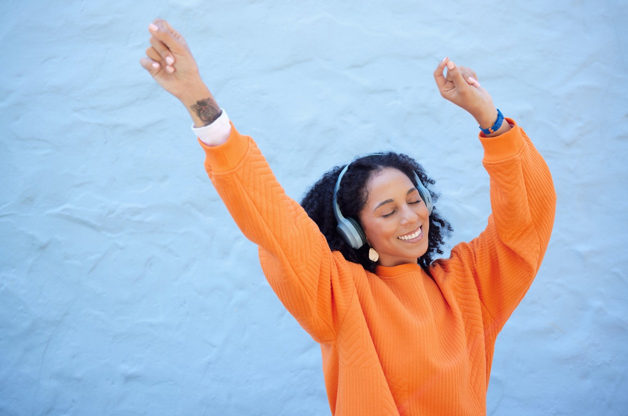Black woman, hands up or dancing to headphones music