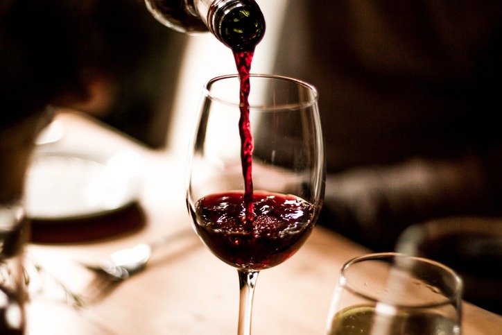 pouring red wine into a glass