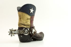an antique cowboy boot with a Texan flag design