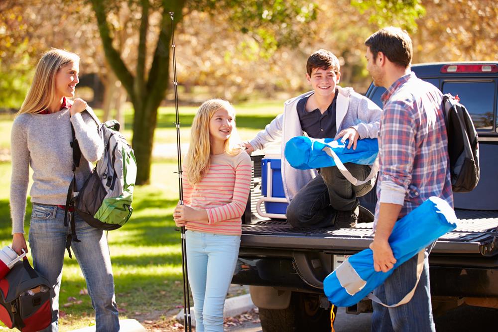 Family packing things on a pickup truck