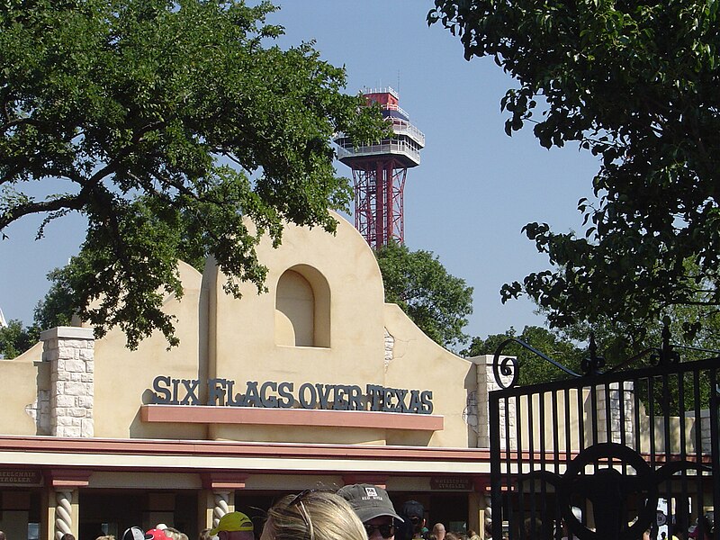 The entrance of Six Flags over Texas welcomes visitors while the Oil Derrick observation tower looms